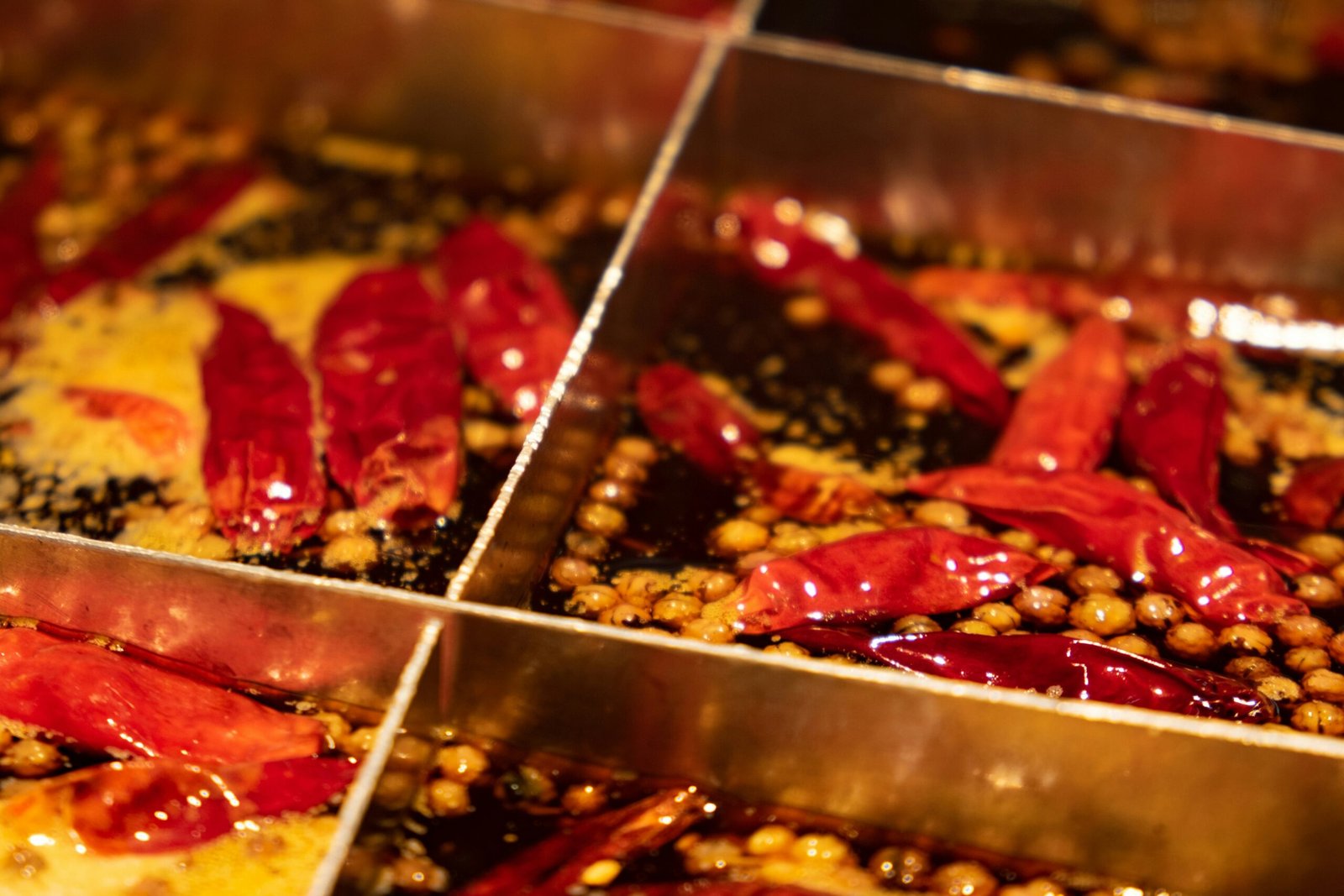 Hotpot med röd, kryddstark buljong på ett delat bord i Chongqing